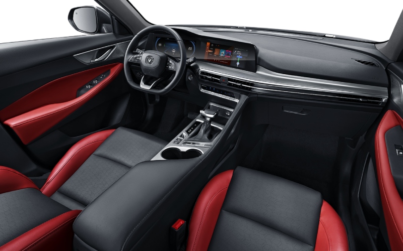 Interior de un Changan CS35 Plus, con un diseño deportivo y moderno. Predominan los colores negro y rojo, y cuenta con una pantalla táctil central.